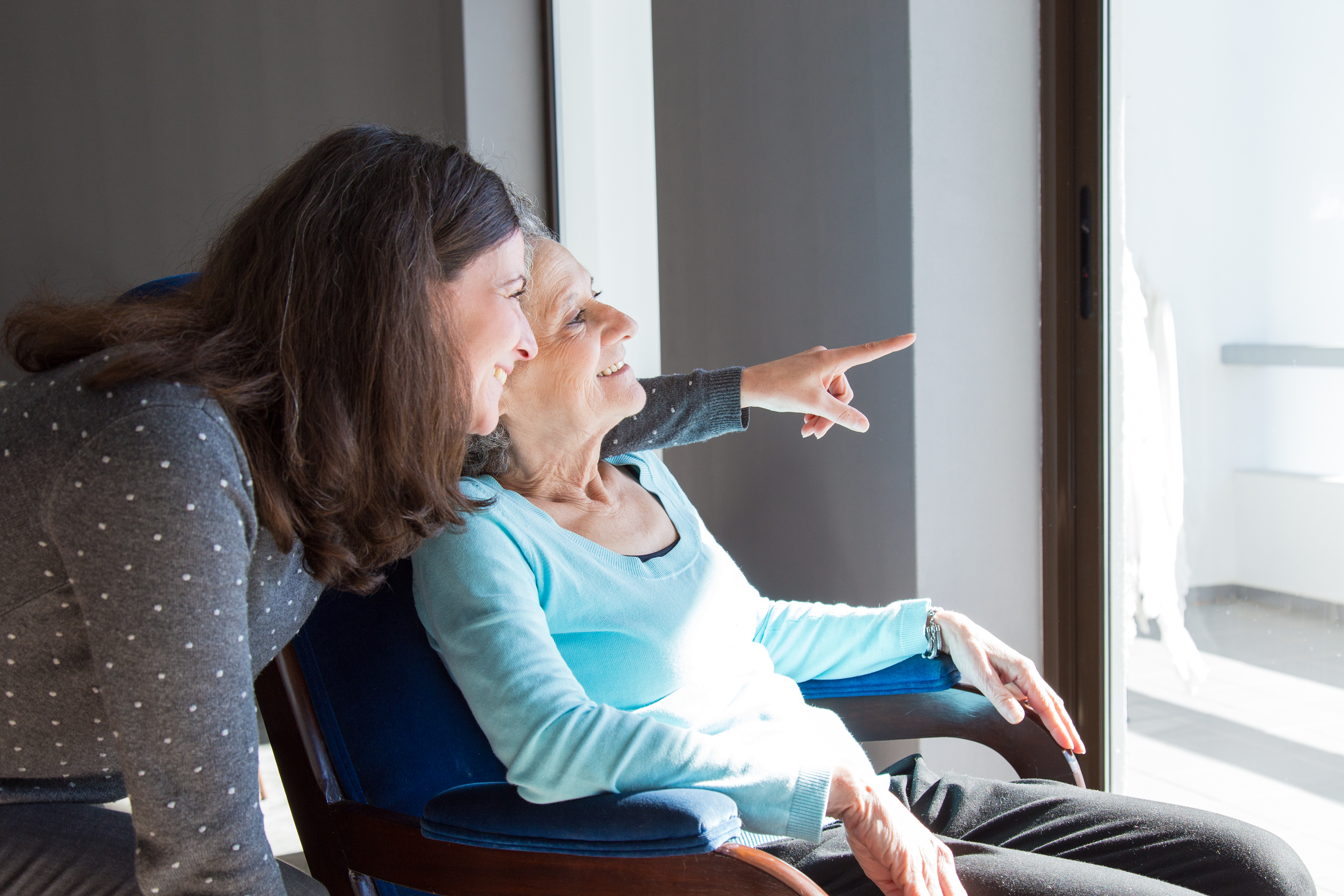 A carer and client sharing a warm moment together, looking out the window